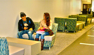 Two students laughing while sitting in Sutter County Lobby